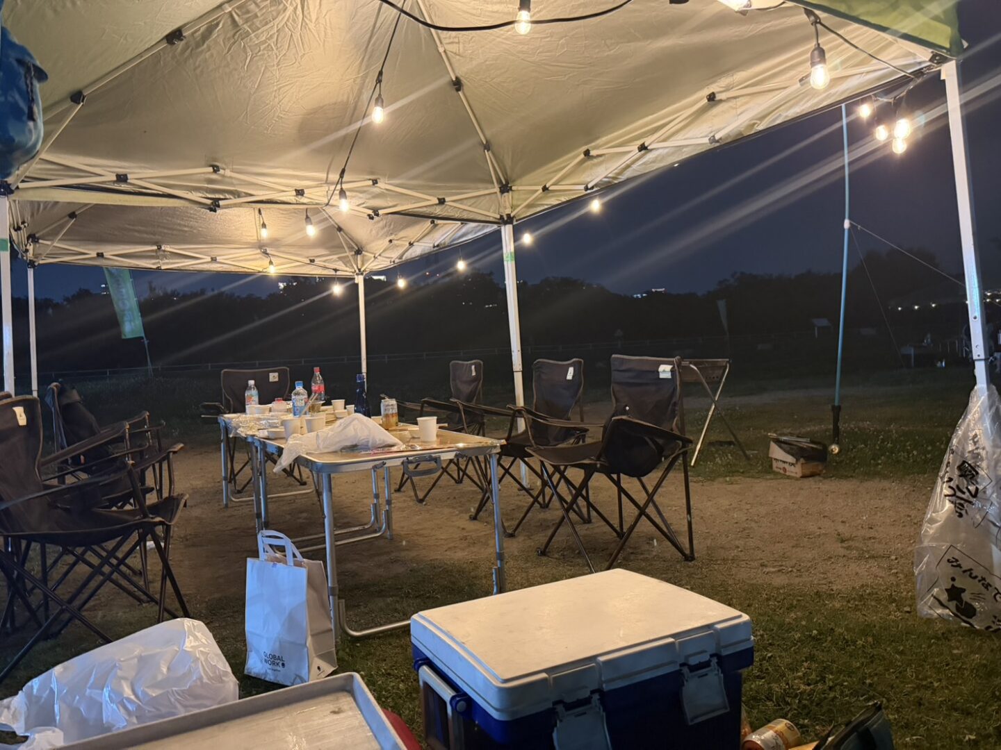 西中島ナイトBBQのテーブルやチェアと電球照明の設置風景